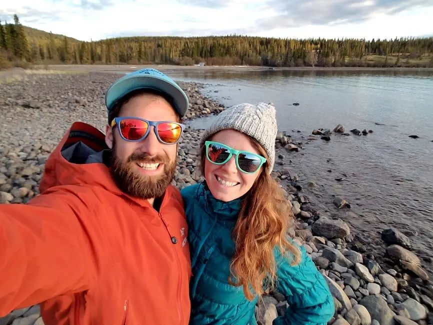 man and woman wearing sunglasses smiiling on teh beach