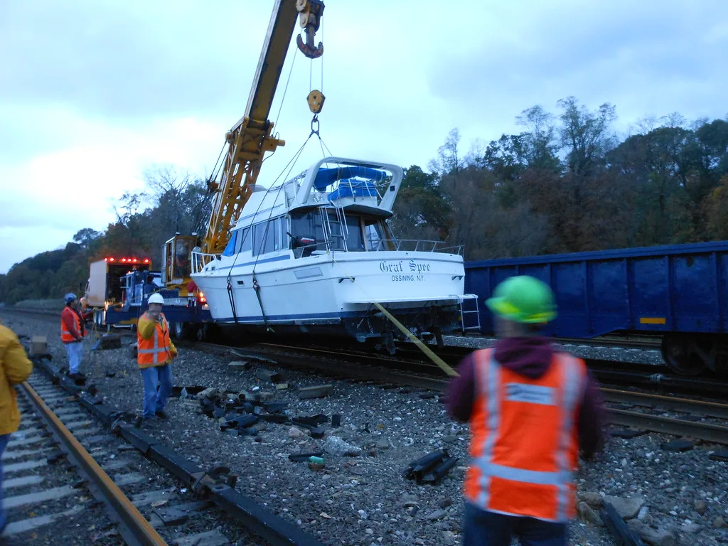 boat being lifted by a crane on railway tracks