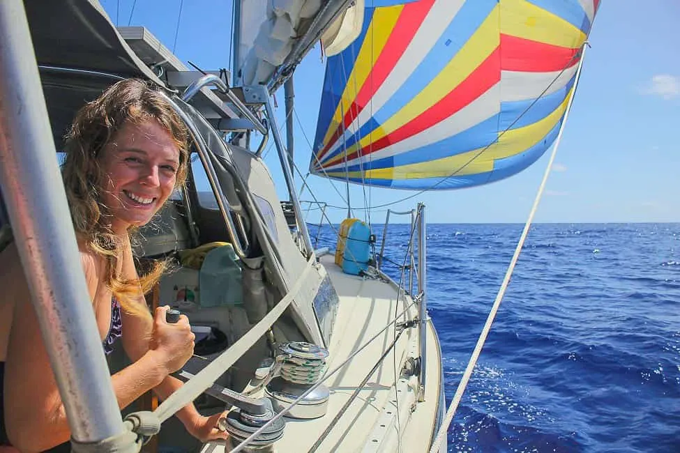 woman smiling and sailing with a colorful spinnaker