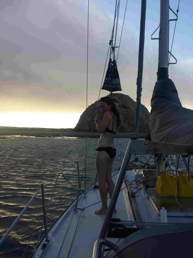 Woman showering on sailboat with a solar shower