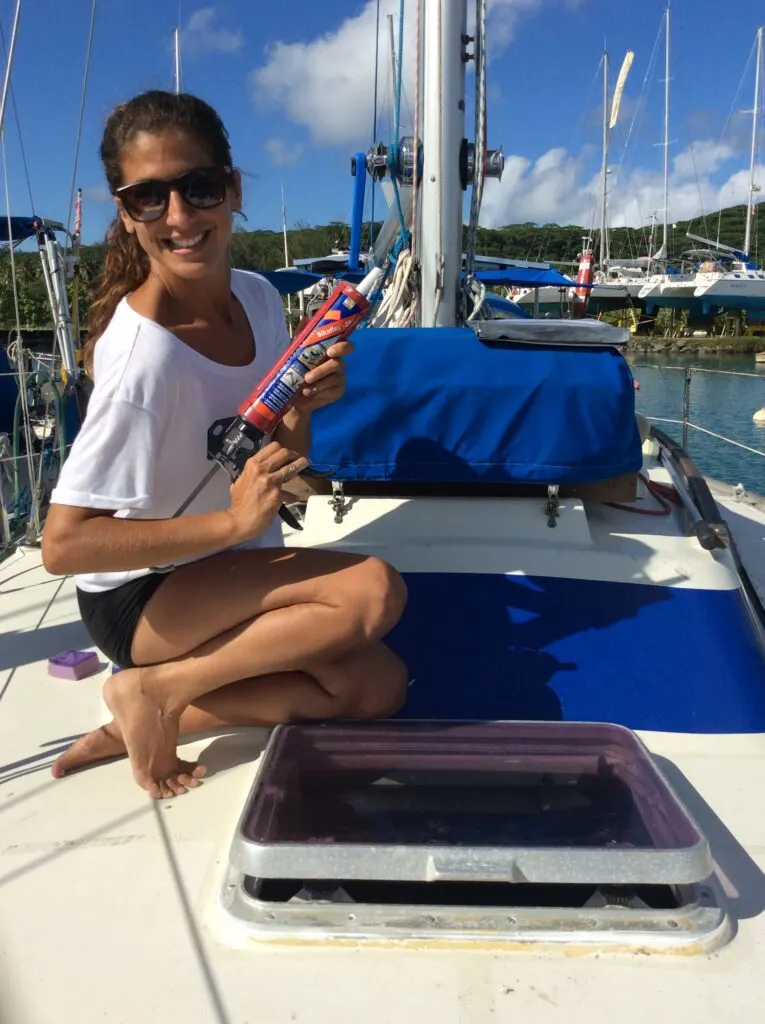 Woman  triumphantly holding Sika Flex sealant after fixing leaky boat hatch