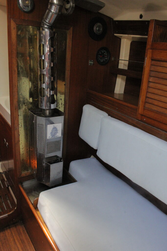 stainless steel stove surrounded by warm wood in a sailboat cabin