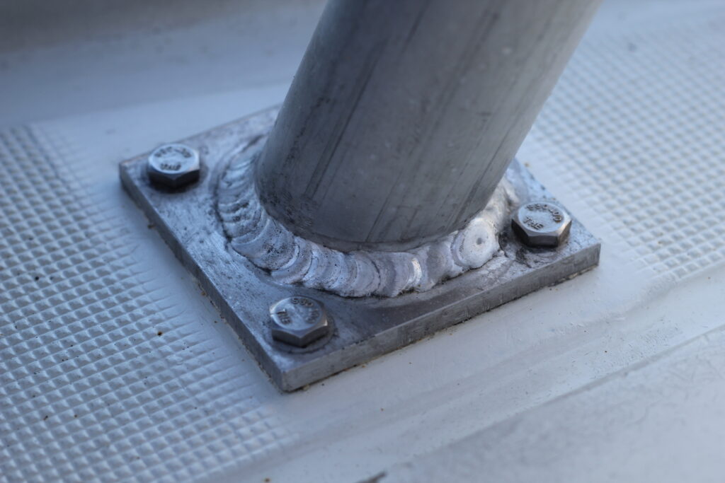 tube end welded to a metal plate fastened to a sailboat deck