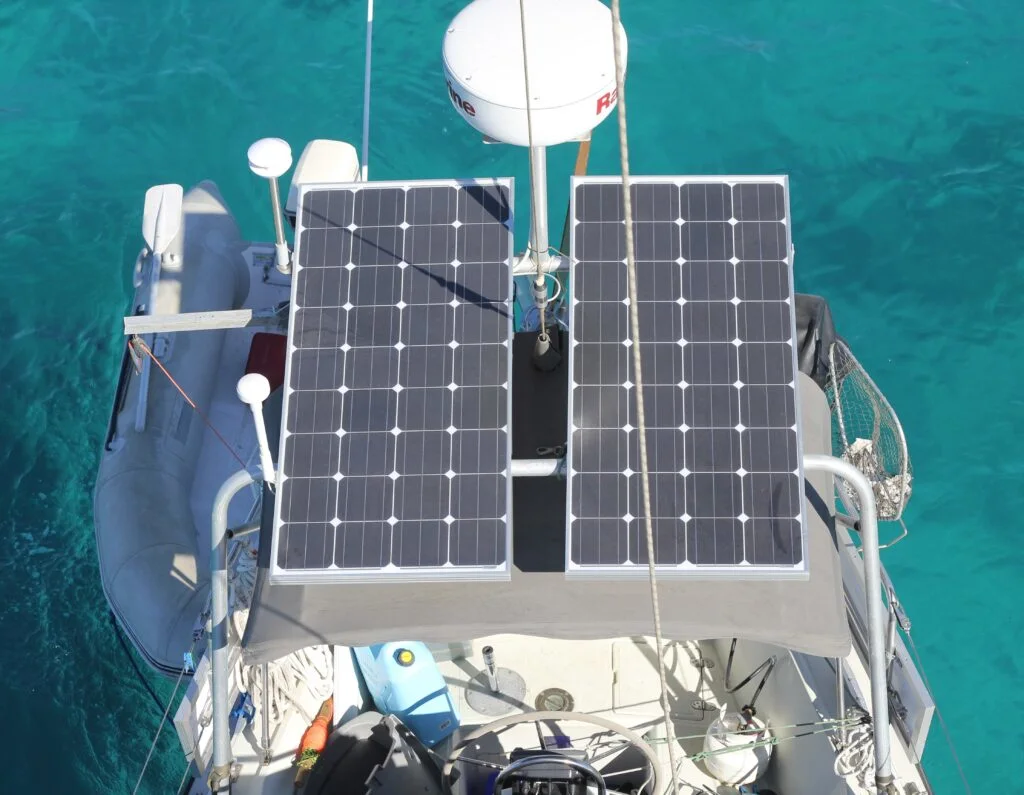 Looking down on two solar panels attached to a solar arch on a sailboat